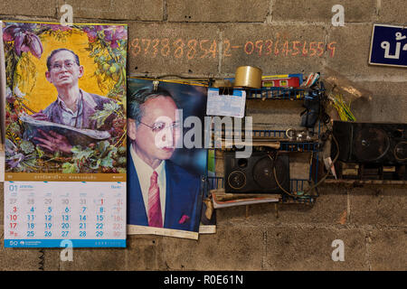 Illustrazione e calendario di Bhumibol Adulyadej, sua maestà il Re di Thailandia, imperniata su una parete del workshop Foto Stock