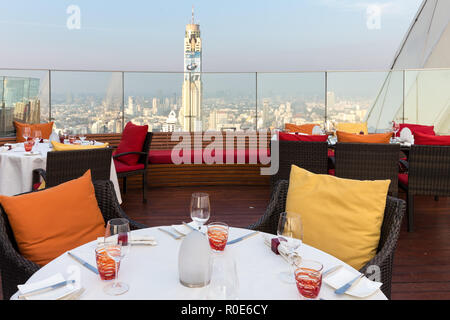 BANGKOK, Thailandia, 14 gennaio 2015: Ristorante tavolo con vista sul Baiyoke Tower e il paesaggio urbano di cielo rosso del tetto del Centara hotel in Foto Stock