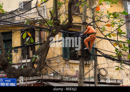 HANOI, Vietnam, dicembre 16, 2014 : Un tecnico è la riparazione o controllo del disordine della rete elettrica nella città di Hanoi, Vietnam Foto Stock