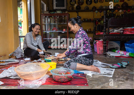 HOI AN, Vietnam, dicembre 14, 2014 : Due donne sedute sul pavimento sono trinciatura di alcuni vegetali e spezie in casa, Hoi An, Vietnam Foto Stock