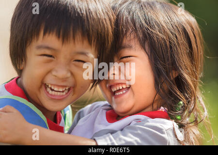 PHANG MAPHA, Thailandia, Novembre 19, 2012 : Ritratto di bambini piccoli fratello e sorella abbracciando e ridere nel villaggio di Phang Mapha, Thailandia. Foto Stock