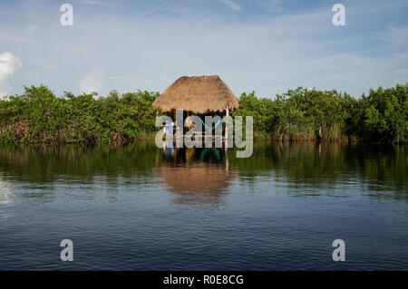 L uomo per rilassarsi in un'amaca con un cenote di Tulum, Messico Foto Stock