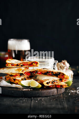 Birra vegetariano snack: quesadilla con verdure e formaggio su sfondo scuro Foto Stock