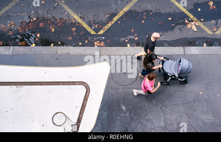 Tre persone a spingere un passeggino sulla strada di Parigi e parlare. Foto Stock