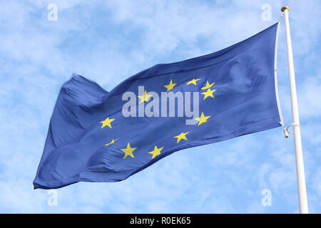 Primo piano della sola bandiera europea con le dodici stelle gialle che sventolano al vento nella parte anteriore del cielo blu Foto Stock