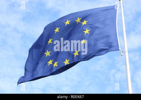 Primo piano della sola bandiera europea con le dodici stelle gialle che sventolano al vento nella parte anteriore del cielo blu Foto Stock