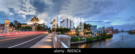 Le luci di Natale incandescenza al tramonto del colorati negozi del villaggio su Venetian Bay in Naples, Florida. Foto Stock