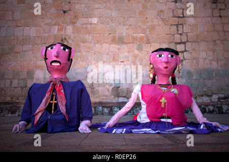 Un paio di gigante in carta pesta bambole noto come 'monos' visualizzato durante una celebrazione religiosa al di fuori del Templo de Santo Domingo in Oaxaca, Messico Foto Stock