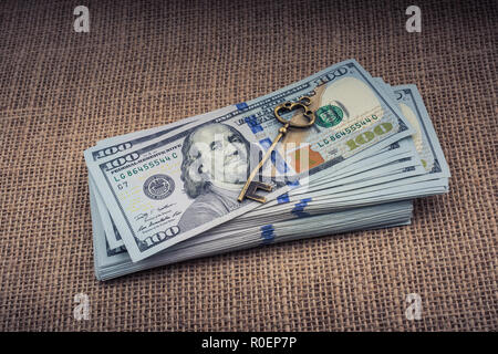 Chiave retrò e fascio di US dollar su una tela di canapa Foto Stock