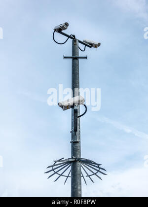 Più telecamere di sicurezza guardando in giù da un palo con il cielo in background Foto Stock