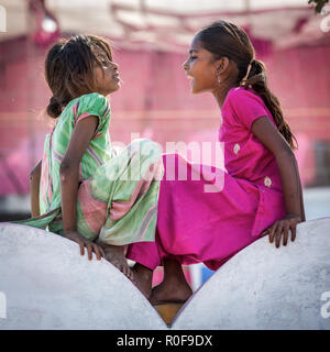 Due ragazze povere seduto su una parete verticale, Pushkar, Rajasthan, India Foto Stock