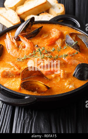 Frutti di mare suquet de peix minestra di patate, le erbe aromatiche e il pesce con aggiunta di picada close-up in una casseruola sul piano verticale. Foto Stock