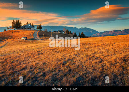 Bella colorata campagna, case rurali e di alta montagna in background con tramonto mozzafiato, crusca, Transilvania, Romania, Europa Foto Stock