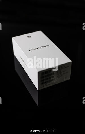 White box di un nuovo P20 Lite mobile smartphone realizzato mediante tecnologia cinese marca Huawei su un lucido la superficie nera Foto Stock