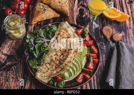 Frittata con avocado, pomodoro, mozzarella, succo di arancia, samsa. Cibo sano Foto Stock