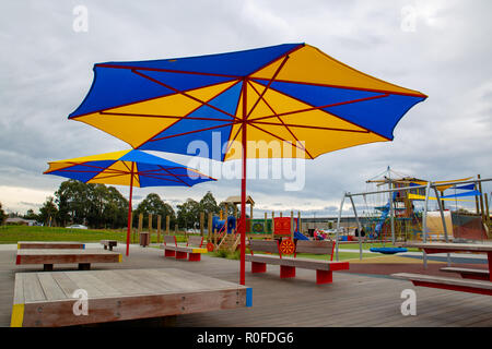 Grandi ombrelloni offrono ombra in corrispondenza di un centro giochi per bambini Foto Stock