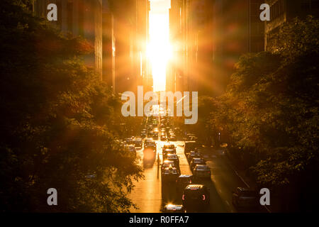 La luce del sole splende overhead su edifici e il traffico sulla 42nd Street attraverso Midtown Manhattan, a New York City Foto Stock