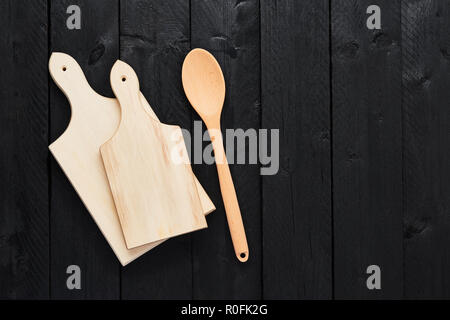 Vista dall'alto di due taglieri e cucchiaino sui tavoli in legno nero con copia spazio. Foto Stock