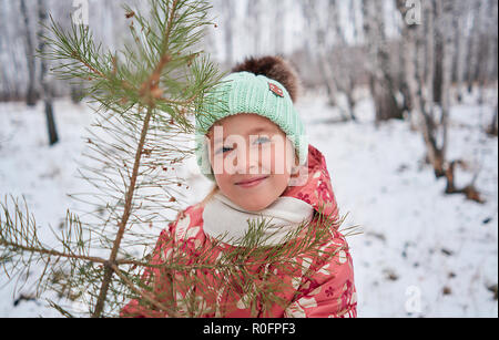 Ragazza in un luminoso hat nella foresta di inverno Foto Stock