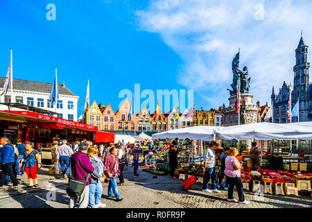 Mercato all'aperto presso la central Markt (piazza del mercato) nel cuore di Bruges, Belgio circondato dalle colorate case medievali con passo Gables Foto Stock