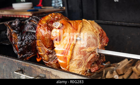 Garretti del prosciutto cotto lentamente la tostatura su fiamme, street food, Repubblica Ceca, Praga Foto Stock