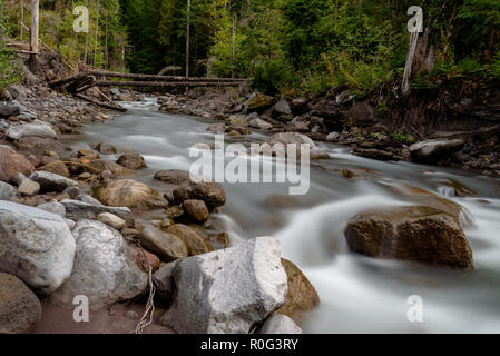 Una lunga esposizione di un rigoglioso fiume di montagna al crepuscolo. Girato nel nord-ovest del Pacifico durante l'autunno. Foto Stock