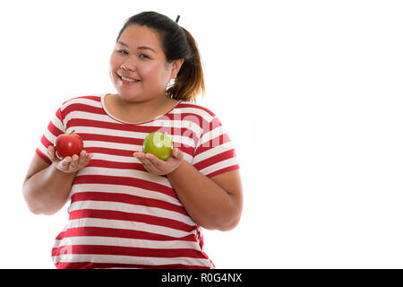 Studio shot di giovani felici fat Asian donna sorridente tenendo premuto Foto Stock