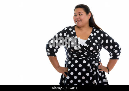Studio shot di giovani felici fat donna asiatica sorridere mentre thinkin Foto Stock