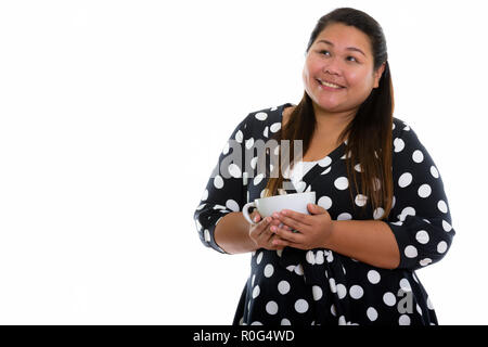 Studio shot di giovani felici fat donna asiatica sorridente e pensare Foto Stock