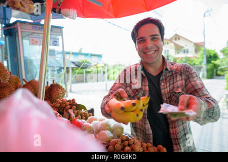 Bello il persiano uomo turistiche shopping per frutti in street shop Foto Stock