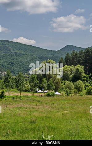 Estate public bivacco con tenda, tavolo, sedia, banner e mettere in campo per la concorrenza, Lozen montagna vicino al villaggio di Pasarel, Bulgaria Foto Stock