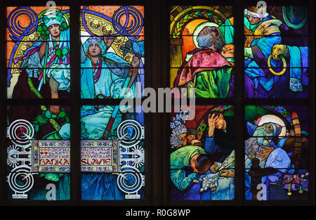 Dettaglio della vetrata progettata da Czech'artista Art Nouveau Alfons Mucha in Saint Vitus Cathedral nel Castello di Praga a Praga, Repubblica Ceca. Le scene della vita dei santi Cirillo e Metodio sono raffigurati in la vetrata a destra da cima a fondo: Papa Giovanni VIII autorizza San Metodio per tradurre la Bibbia in lingua slava; la morte di san Metodio nell'Impero della Grande Moravia. Foto Stock