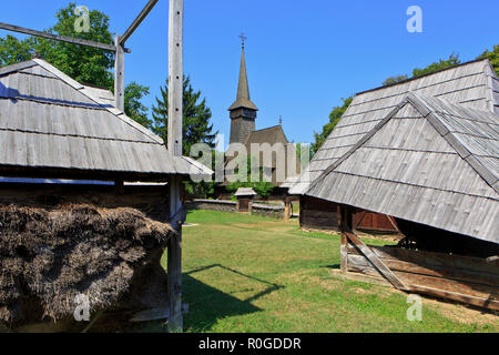 Una bella chiesa di legno tra vari masi al Dimitrie gusti nazionali museo del villaggio di Bucarest, Romania Foto Stock