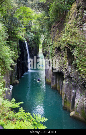 Splendida vista Takachiho gorge con piccole imbarcazioni da fiume al di sotto di una cascata, Giappone. Foto Stock