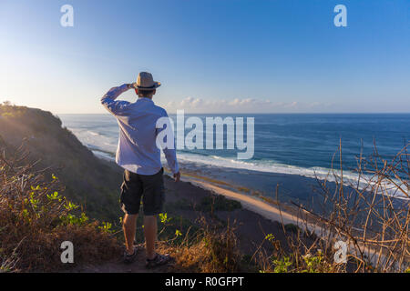 L'uomo sorge su una scogliera sul mare Foto Stock