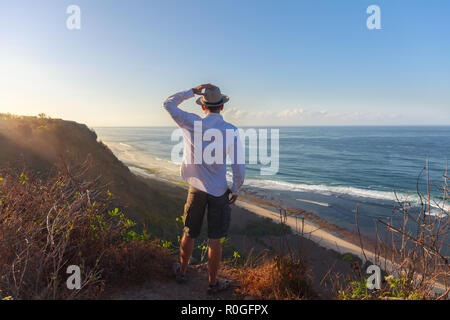 L'uomo sorge su una scogliera sul mare Foto Stock