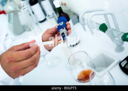 Vista sul vino rosso essendo controllato sulla componente saturazione nel laboratorio chimico sulla fabbrica di cantina Foto Stock