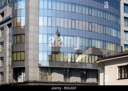 Immagine distorta della vecchia cattedrale ortodossa nelle finestre del moderno edificio della città Foto Stock