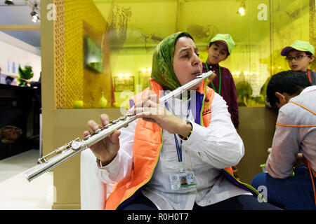 Nord Africana di donna che indossa un verde jihab riproduzione di flauto traverso nella parte anteriore dei giovani nella Conferenza delle Nazioni Unite sul Cambiamento Climatico Marrakech Maroc Foto Stock
