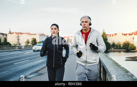 Montare un paio di cuffie all'esterno in esecuzione sul ponte nella città di Praga. Foto Stock