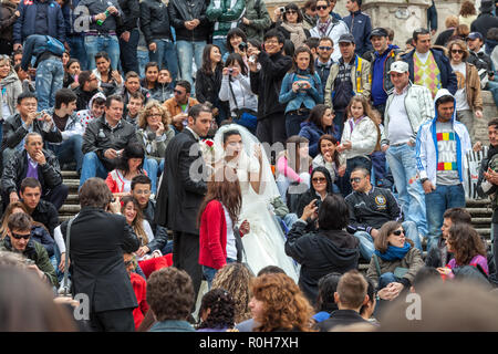 Felice sposa e sposo nel mezzo di una folla di turisti sulla scalinata di Trinita dei Monti. Roma, Lazio, Italia, Europa Foto Stock