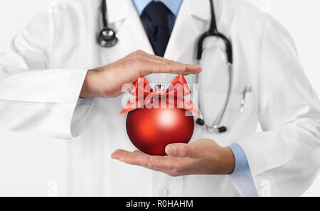 Auguri di Buon Natale dal medico,, auguri concetto, le mani con il natale pallina rossa, gift card banner web Foto Stock