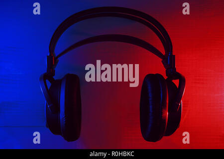 Cuffie con neon blu e luci rosse su sfondo scuro Foto Stock