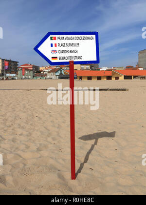 Avviso di spiaggia custodito in varie lingue isolato su bianco Foto Stock