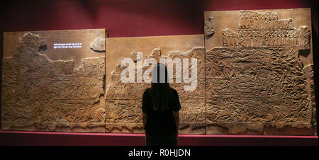 Londra, Regno Unito. 5 Novembre, 2018. Il British Museum. Un membro del personale guarda 'Battaglia di Til-Tuba' mostra presso il British Museum è sull antico Iraq nel VII secolo a.c. quando divenne Ashurbanipal la persona più potente sulla terra. Dalla sua capitale a Ninive, egli dominava un vasto e diversificato impero, sagomando la vita dei popoli dalle sponde del Mediterraneo orientale delle montagne dell'Iran occidentale. Credito: Dinendra Haria/Alamy Live News Foto Stock