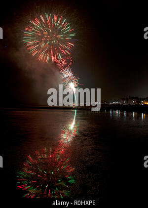 Musselburgh, Scozia, Regno Unito, 5 nov. 2018. Guy Fawkes fuochi d'artificio riflessa nella sabbia bagnata. Insolitamente mite a 9 gradi per la East Lothian town annuale gratis Fireworks display a cui hanno partecipato anche a più persone a causa della chiusura di Edimburgo di Meadowbank Stadium. Foto Stock