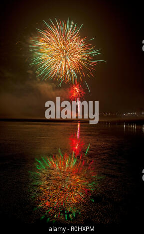 Musselburgh, Scozia, Regno Unito, 5 nov. 2018. Guy Fawkes fuochi d'artificio riflessa nella sabbia bagnata. Insolitamente mite a 9 gradi per la East Lothian town annuale gratis Fireworks display a cui hanno partecipato anche a più persone a causa della chiusura di Edimburgo di Meadowbank Stadium. Foto Stock