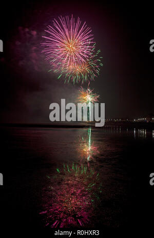 Musselburgh, Scozia, Regno Unito, 5 nov. 2018. Guy Fawkes fuochi d'artificio riflessa nella sabbia bagnata. Insolitamente mite a 9 gradi per la East Lothian town annuale gratis Fireworks display a cui hanno partecipato anche a più persone a causa della chiusura di Edimburgo di Meadowbank Stadium. Foto Stock