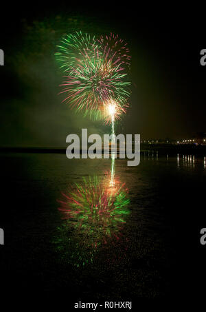 Musselburgh, Scozia, Regno Unito, 5 nov. 2018. Guy Fawkes fuochi d'artificio riflessa nella sabbia bagnata. Insolitamente mite a 9 gradi per la East Lothian town annuale gratis Fireworks display a cui hanno partecipato anche a più persone a causa della chiusura di Edimburgo di Meadowbank Stadium. Foto Stock