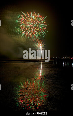 Musselburgh, Scozia, Regno Unito, 5 nov. 2018. Guy Fawkes fuochi d'artificio riflessa nella sabbia bagnata. Insolitamente mite a 9 gradi per la East Lothian town annuale gratis Fireworks display a cui hanno partecipato anche a più persone a causa della chiusura di Edimburgo di Meadowbank Stadium. Foto Stock